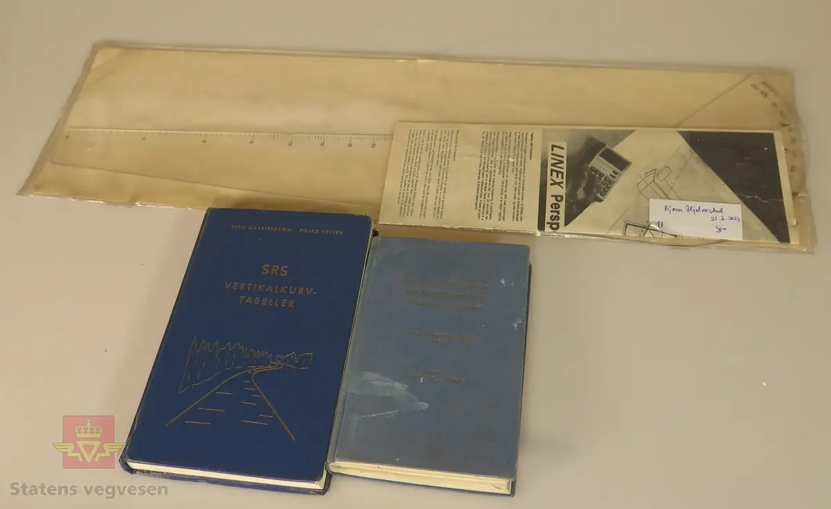 13 objekter.
Tabeller:
1.	Tafeln zum Abstecken von Kreiskurven und Übergangsbogen av j. Gysin og E. Moll. Liestal 1962
Tabellen ble brukt til beregning av utstikkingsdata av horisontalkurver (sirkler og klotoider)

2.	SRS, Vertikalkurv-tabeller. Stein Gabrielsson og Folke Keller. 1965
Tabellen ble brukt ved beregning av høgder i vertikalkurver som endrer stigningsforholdene på en veg.

Tegneutstyr-måleutstyr:
1.	Transportør i stål. Halvsirkel. Merket Gundersen og Løken A/S, Pilestredet Svart kasse ca 33/17/4 cm. Transportøren består av en halvsirkel med gradinndeling langs ytterkanten. Langs den rette kanten er det en linjal med millimeterinndeling. Midt på linjalen, det vil si i sentrum av halvsirkelen, kan det settes ei nål som transportøren kan dreies rundt.
Ved konstruksjon av kart basert på innmåling i terrenget, ble koordinatfestede punkter (polygonpunkter) først merket av på kartplata. Nåla på transportøren ble dretter satt ned i et avmerket polygonpunkt. Så ble detaljpunkter avsatt ved å dreie transportøren i henhold til avlest vinkel ved innmåling og måle ut avstanden som var registrert ved innmåling i terrenget. 
Utstyret ble blant annet brukt ved tegning av ferdigvegskart som dannet grunnlag for eiendomserstatninger (se beskrivelse av planimeter).

2.	Klotoidesøker i omslag (papp) 
3.	Kurvelinjal med forskjellige radier.
4.	Rotring R5333360. Tusjpenner brukt ved tegning og skrift på planer.
5.	Rotring Izograph F, Zeichenkegel. Tusjpenner brukt ved tegning og skrift på planer.
6.	Standardgraph Lettering sets. Et sett med sjablonger som ble brukt ved teksting av kart og tegninger. Skriftsjablongene fantes i mange forskjellige størrelser. I dette settet er det også med tusjpenner (spisser) i ulike tykkelser tilpasset forskjellige sjablonger. Skaft med tusjbeholdere ble festet til spissene.
7.	Orange og grønne kurvesjablonger. Sjablonger brukt som støtte ved manuell konstruksjon og opptegninga av vegplaner.
8.	Standardgraph Tegneustyr
9.	Planimeter i eske c 15/10/5 CM: G. Conradi AG, Zürich Tegnere Plan 571.9-4. Et planimeter, eller en flatemåler, ble brukt til å finne flateinnholdet av arealer på kart. Ved å føre et punkt som en ser i lupa langs ytterbegrensningene av ei «lukket» flate, får en ut arealet i vinduet på den grønne boksen. I forbindelse med beregning av grunnerstatning etter at en veg var bygget eller utvidet, ble planimeteret brukt for å få fram arealer som vegvesenet måtte erverve.
10.	Trekasse med transportør. Signert Sigurd Baalsrud. Transportøren består av en halvsirkel med gradinndeling langs ytterkanten. Langs den rette kanten er det en linjal med millimeterinndeling. Midt på linjalen, det vil si i sentrum av halvsirkelen, kan det settes ei nål som transportøren kan dreies rundt.
Ved konstruksjon av kart basert på innmåling i terrenget, ble koordinatfestede punkter (polygonpunkter) først merket av på kartplata. Nåla på transportøren ble dretter satt ned i et avmerket polygonpunkt. Så ble detaljpunkter avsatt ved å dreie transportøren i henhold til avlest vinkel ved innmåling og måle ut avstanden som var registrert ved innmåling i terrenget. 
Utstyret ble blant annet brukt ved tegning av ferdigvegskart som dannet grunnlag for eiendomserstatninger (se beskrivelse av planimeter).

11.	Linex Perspector: spesial linjal, lang
