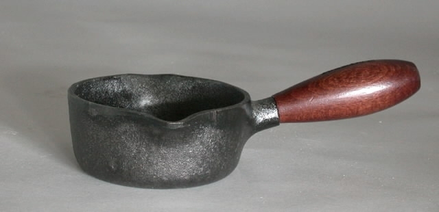 Gjutjärnskastrull, rund, med trähandtag. I originalkartong.