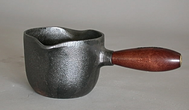 Gjutjärnskastrull, rund, med trähandtag. I originalkartong.