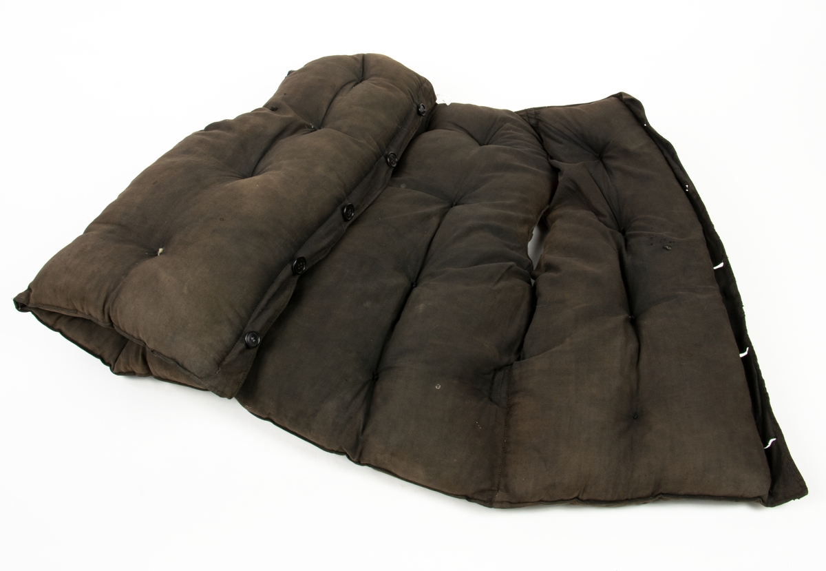 Flytväst Tjockt vadderad mörkbrun flytväst. Enkelknäppt med fem knappar, en ficka på vänster framstycke. Förmodligen vadderad med Kapok.