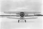 Flygplan B 4 Hawker Hart nr 704 uppställd utanför hangarerna på Centrala verkstäderna Malmen, vintertid 1936. Vy framifrån. Flygplanet var det första av CVM:s licenstillverkade Hawker Hart.