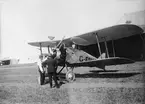 Brittiskt flygplan Gloster G.17 Gamecock märkt G-EBNT uppställd på Internationella luftfartsutställningen i Göteborg (ILUG) på Torslanda 1923. Två män vid flygplanet.