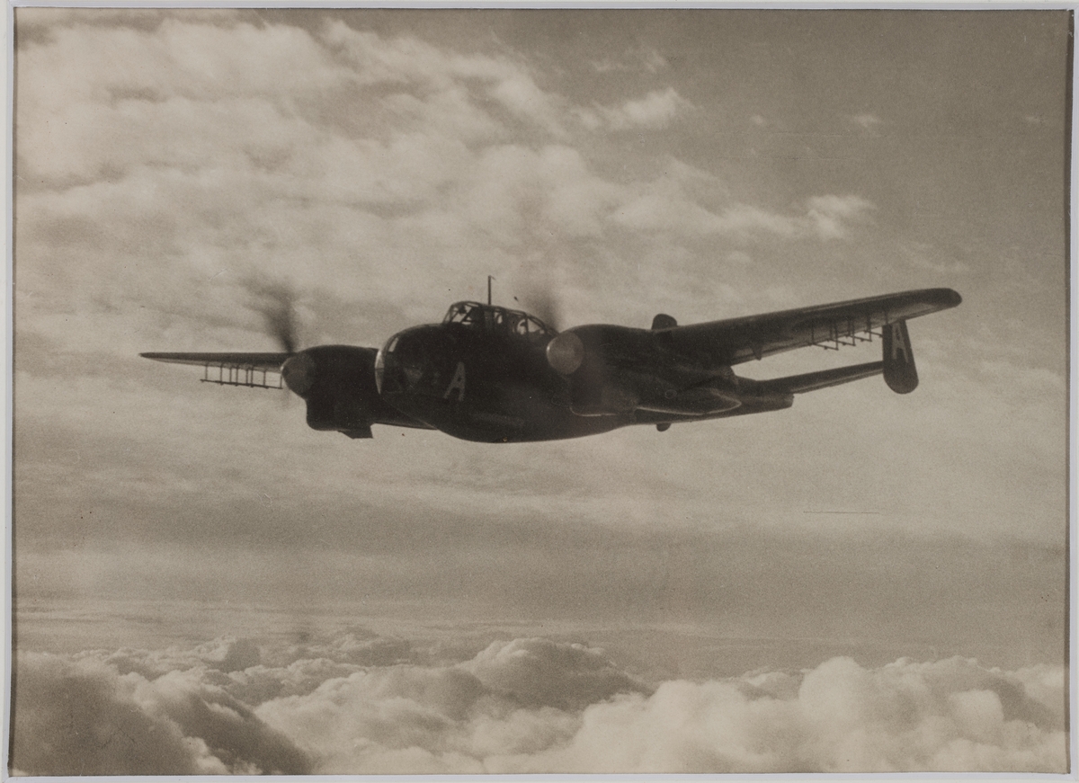Fotografi inom ram av mahogny. På ramen en bricka av nysilver med inskriptionen: F 17 Bärgning av flp. T 18 B jan. 1949.
På tavlans baksida följande text: Skänkt till gunrummet H.M Minsveparen Holmön av chefen för F17 som minne av bärgningen av det vid Karlshamn i januari 1949 störtade flygplanet. B. Bergman F L. Texten på baksidan som här utgöres av: Skänkt till UO-mässen.
Neg.nr 4928.