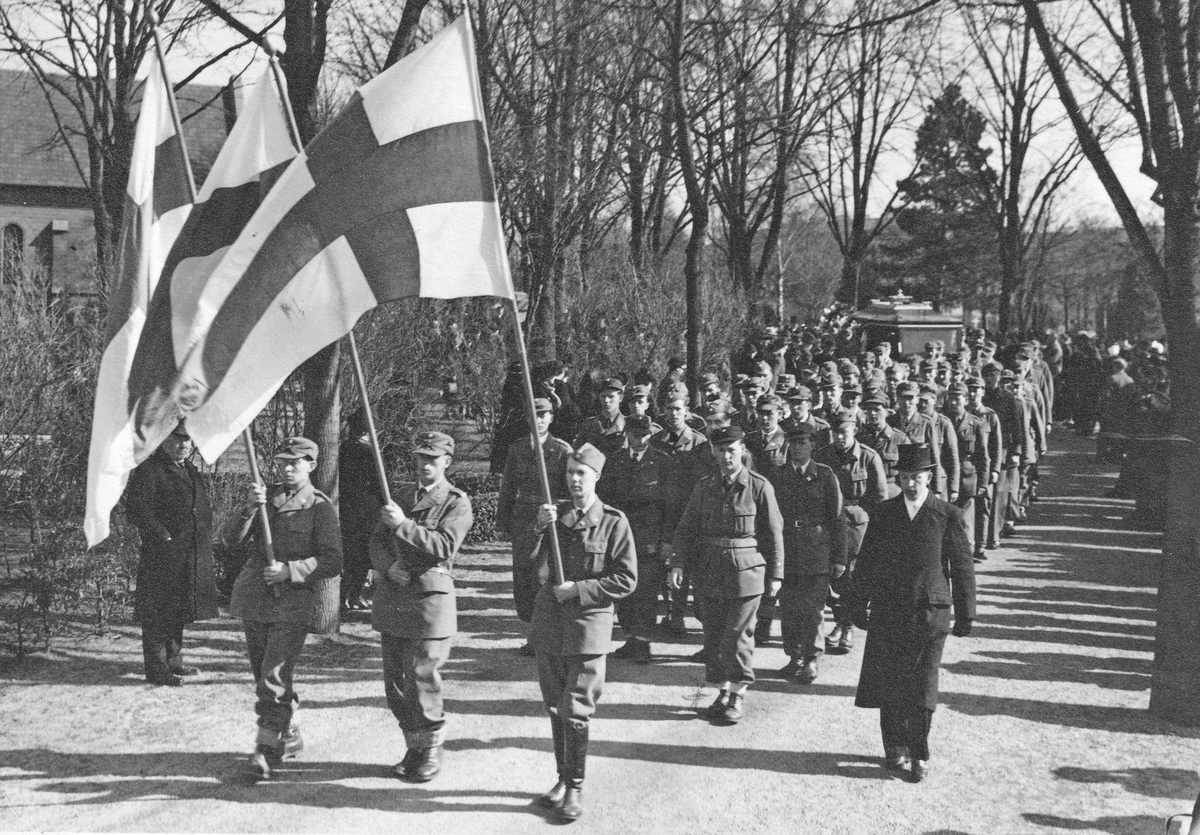 Svenska Frivilligkåren. Översergeant Bror Persson i spetsen bakom fanorna.