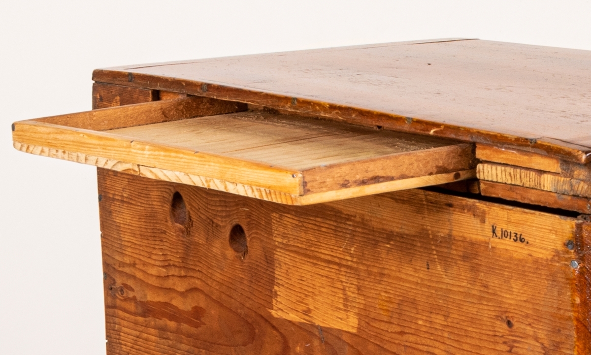 Sybyrå, barock typ, med tandning under skivans kanter. Miniatyrbyrå, med tre draglådor med fanér, delvis i rutmönster. Gjutna bronshandtag. Kulfötter. Obs. en liten smal låda upptill på byråns baksida.