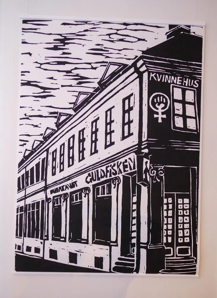 Foto tatt i utstillingen Lesbene gjør opprør: lesbiske feminister på 1970- og 80-tallet. Foto viser en bildeplansje. Motivet er en tegning av eksteriøret til Kvinnehuset i Oslo.