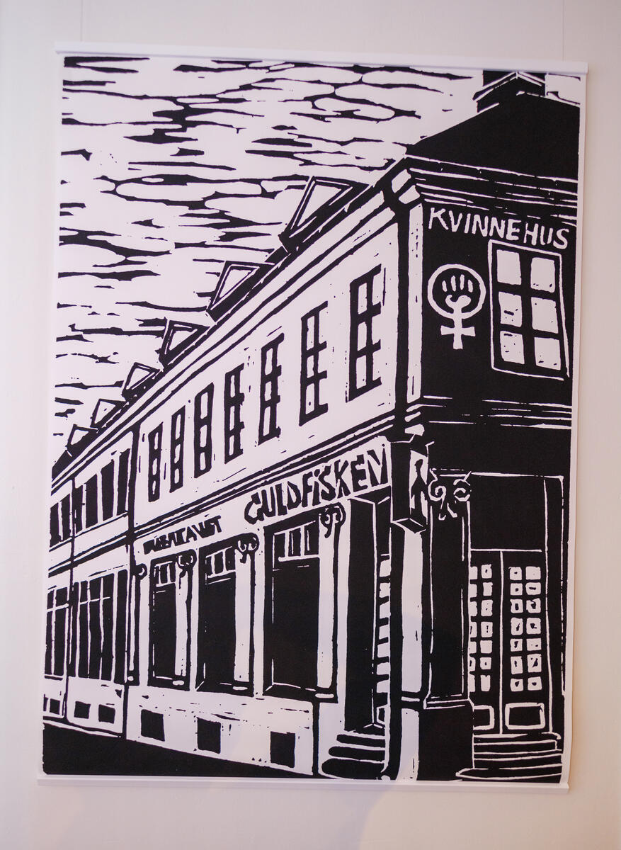 Foto tatt i utstillingen Lesbene gjør opprør: lesbiske feminister på 1970- og 80-tallet. Foto viser en bildeplansje. Motivet er en tegning av eksteriøret til Kvinnehuset i Oslo.