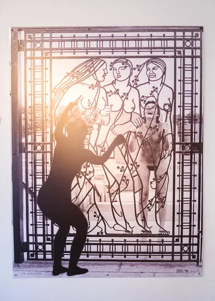 Bilde av et fotografi som hang på veggen i utstillingen Lesbene gjør oppgjør: lesbiske feminister på 1970- og 80-tallet. Foto viser en kunstperformance som den lesbiske performancegruppa med navnet Seriøsgruppa utførte i Vigelandsparken. Utgangspunktet for performancen var en port i Vigelandsparken som viser tre nakne damer.