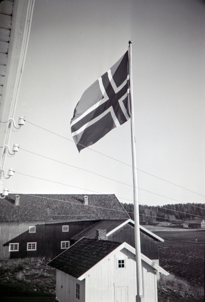 Flagg på flaggstanga på Hol Vestre i Vang kommune, Låven i bakgrunn. Fra slutten av 1970-tallet.