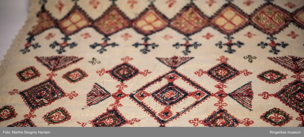 Brodert veggteppe eller duk. Selve stoffet er vevd i lerretsbinding. Nederst på veggteppet går renningen i veven over i et panel i sprang. Dette panelet er ca. 18 cm langt, og består av diamant-former. Langs kanten av veggeteppet er det en tynn bord, denne er enten laget i sprang eller heklet. Borden går nesten til toppen av stoffet, men slutter 7 cm før kanten.

Det er fem felter med broderier. Feltet i midten er større enn de andre, og blir ikke gjentatt. Det øverste og det nederste feltet er nesten helt like, det samme gjelder for det nest øverste og det nest nederste. Helt nederst, før sprang-panelet, er det en smal sikksakk-bord. Broderiet er preget av kors og geometriske former.

Veggteppet bærer preg av slitasje. Det har hull flere steder. Øverste venstre hjørne har en stor rift. Øverste høyre hjørne har et hull som kan ha vært brukt til oppheng (en annen teori er at det kan ha vært rullet rundt en stokk, men dette ville skjult den øverste delen av broderiet). Teppet er jevnt over mer slitt på venstre side. Nederste panel er også litt lysere i fargen enn det øverste. Det er også hull i sprang-panelet nederst. 
