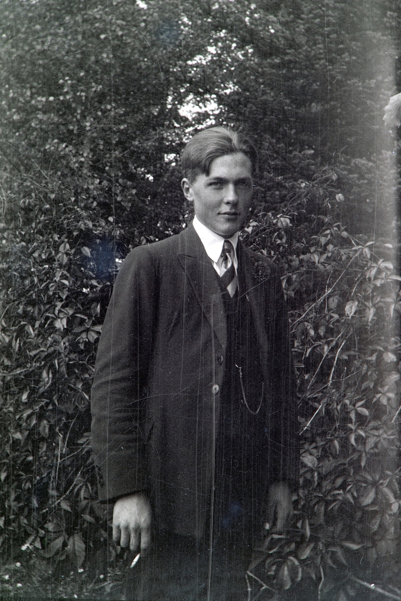 Portrett av Odvar Kristen Gjestvang (1908-2002) ute i hagen på Nordre Ottestad, Stange. ca 1930.