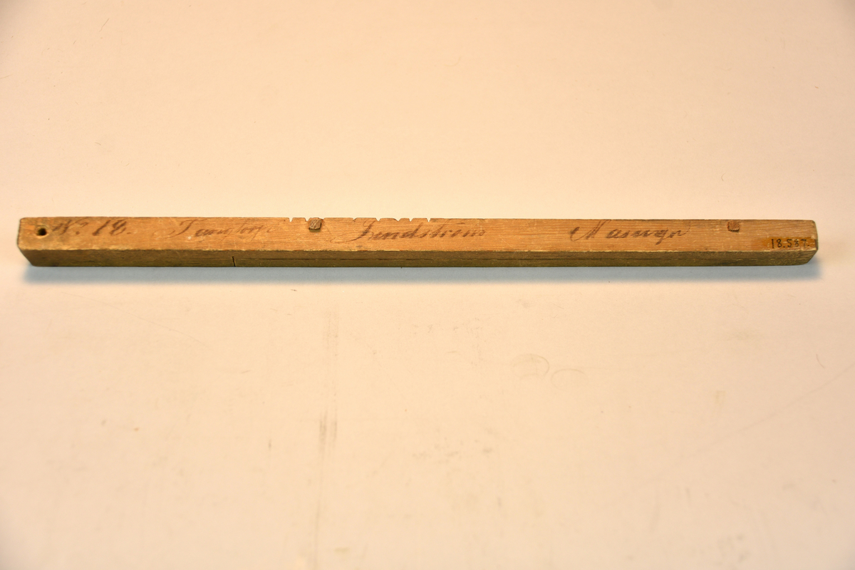 I två delar. Text: "No 18 Tangtorp Lindström Masugn". Brännstämpel: "NK". För var gång stickans båda delar är fulla med sågskåror, hyvlas dessa bort.