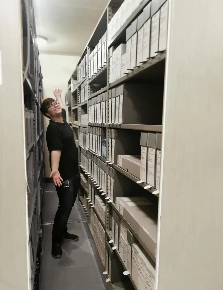 Mann blant arkivbokser