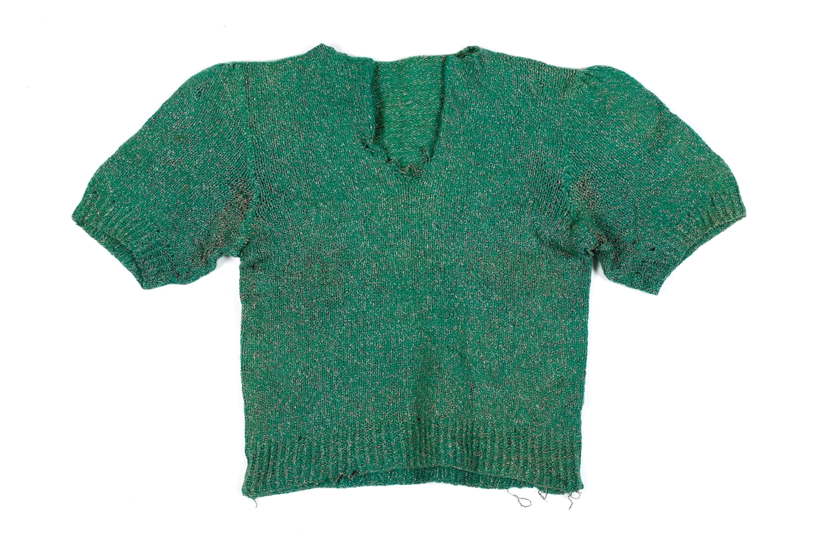 Genser fra 1960-tallet. Den er strikket med to garn, et grønt og svart/hvitt. Den har korte ermer og kaftanhals. Ribbestrikk i livet og i ermene. 