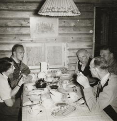 Martin Tranmæl inntil veggen på høyre side i Martinhytta, Kr