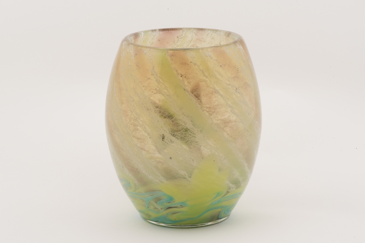 Välsad glasvas i jugendstil.
Svagt bukig vas med växtmotiv. Invälsad spiralvriden flockig glasmassa i vitt, gröngult, grönblått och mörkblått. Påklippt och invälsad blomma i form av en violett akleja samt ett grönt blad.