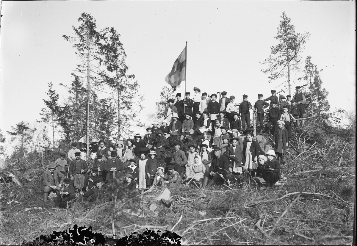Barn, kvinnor och män med redskap i naturen, Östhammar, Uppland
