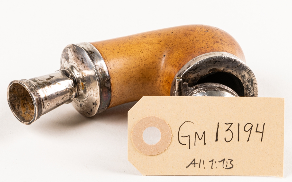 Långpipa, av sjöskum, med träskaft och benmunstycke. Silverbeslag med stämplar: "G5", "AA", samt tre kronor. År 1861.