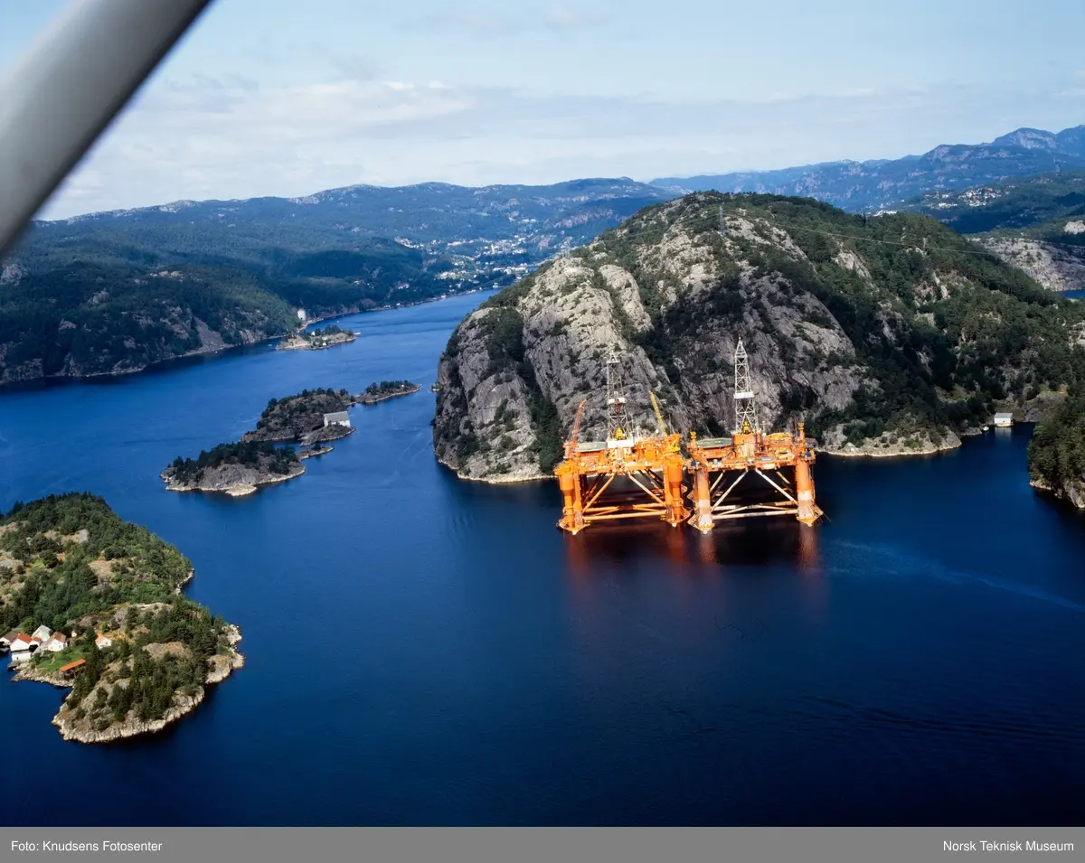 To boreplattformer ved land i Straumsundet i Flekkefjord fotografert fra fly.