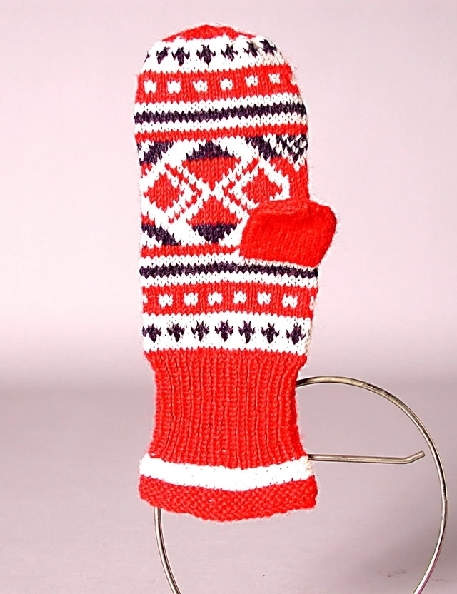Stickad vantar i rött, vitt och blått ullgarn. Mudden resårstickning med 3 cm. rätstickning i kanten, i övrigt slätstickning.
