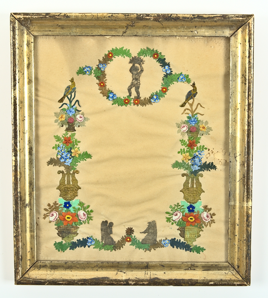 Gratulationstavla från 1840- 50-talet. Av papper med plats för text inom en ram av nedtill: blomsterrankor med två änglar, vid sidorna: urnor med blommor bildande pelare, vardera med en fågel överst. Upptill: inom en krans av blommor stående kerub med blomsterurna över huvudet. Ingen text. Glasad och inramad med förgylld list.