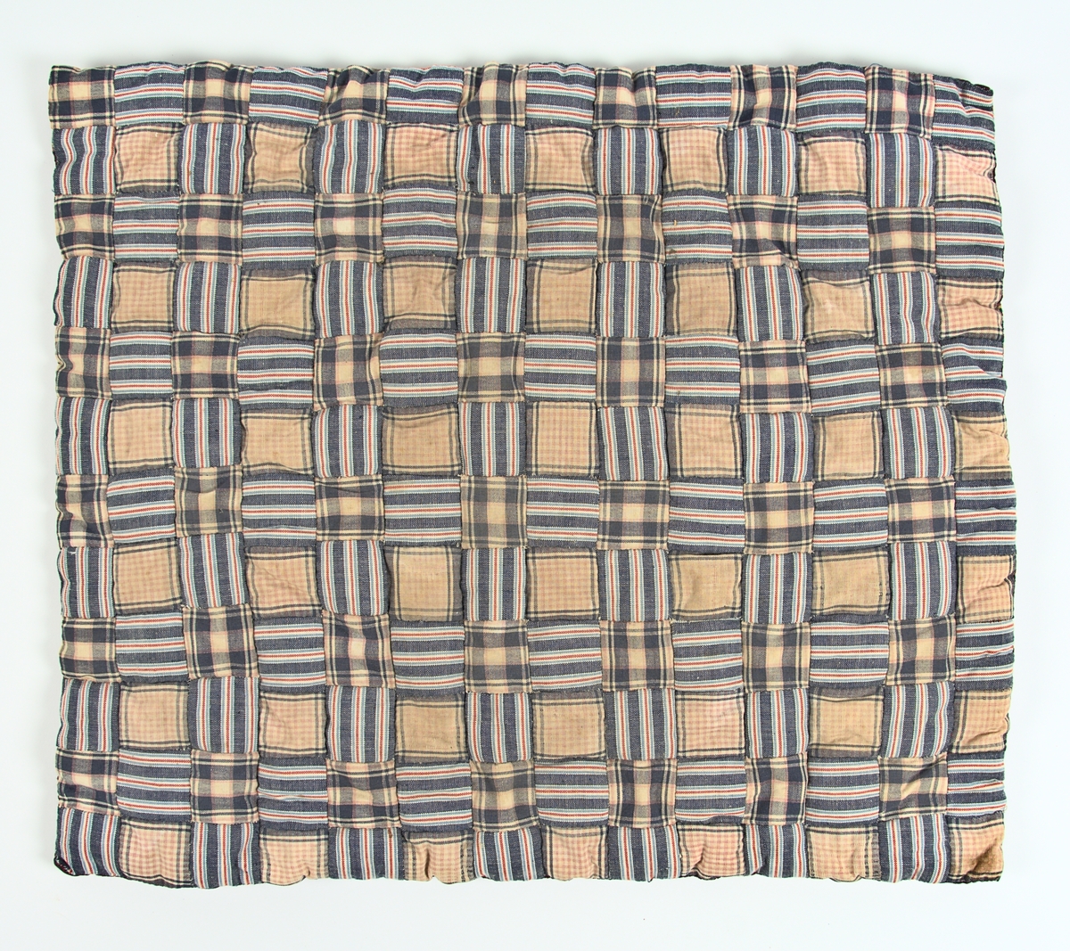 Lapptäcke av bomull. Lappar ca 4,5x4,5 cm. Randigt foder av bomullstyg. Stoppad med vadd.
