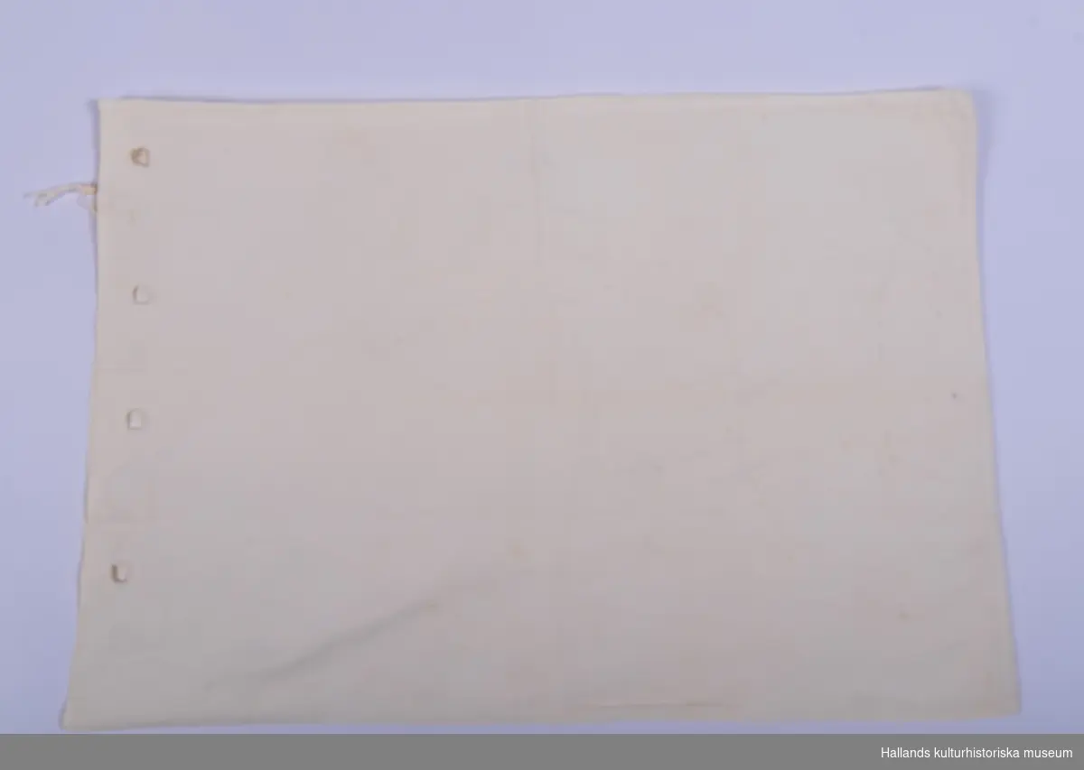 Stickpåse av vit bomull. Märkt: "44", broderat med röd tråd mitt på påsen.