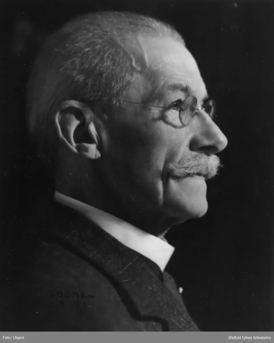 Portrett av Gunerius Furuholmen,ordfører 1896-98 Høyremann. Ingeniør, bestyrer ved Furuholmen lense. "Fusket" i arkitektfaget, tegnet bl.a. Breidablikk og Bygdehallen. Restaurering av Varteig kirke i 1911, nedla et stort arbeid i det kristelige liv, samt musikk. Slektsgransker. Kongens fortjenestemedalje i 1935.