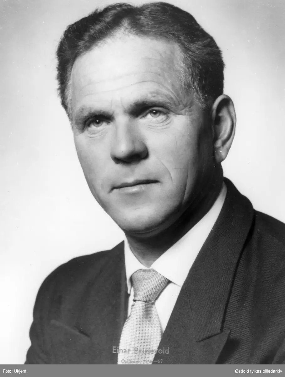 Portrett av Einar Brusevold. Ordfører i Varteig 1956-63 og 1972-1979. Medlem av kommunestyret i en årrekke, fylkestinget, møtt på Stortinget som varamann, i Varteig Spareb bank og ved fusjonen til Sparebanken Borg og senere Nor. Gårdbruker, representerte Senterpartiet.