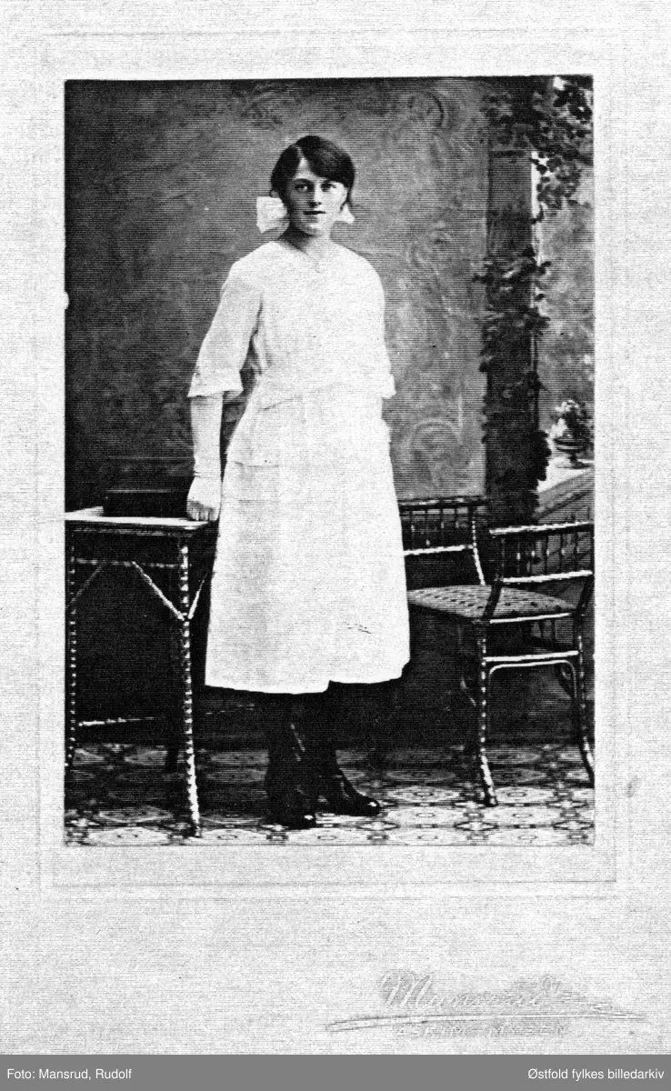 Portrett av Olga Grefsli, adoptivdatter til Ole og Mina Grefsli, som drev Grefsli pensjonat i Trøgstad. Ant. er det konfirmasjonskjole piken har på seg. Tatt ca. 1920? Gift med Ola Gjeterud, flyttet til Mysen og siden Sarpsborg, døde ca. 1990.