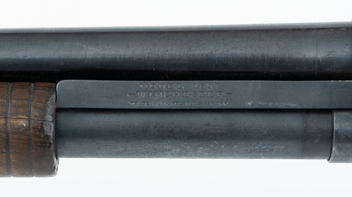 Winchester Model 1897, ei pumpehagle med rørmagasin, produsert av Winchester Repeating Arms Company i New Haven i Connecticut i USA (1866-2006). Dette våpenet er også kjent som Model 97, M97, eller Trench Gun. Model 1897 var en videreutvikling av Winchester Model 1893. Formgiveren bak disse våpnene var børsemakeren John Moses Browning (1855-1926). Magasinet sitter på undersida av løpets bakre del. Det er omgitt av et sylindrisk treskjefte. Når dette handtaket trekkes tilbake, trekkes også sluttstykkebolten bakover, slik at den tomme patronen kastes ut. Når det nevnte handtaket skyves framover igjen mates en ny patron inn i kammeret. Magasinene i Model 97 hadde vanligvis rom for 6 haglpatroner. Våpenet har full trangboring, det vil si at løpet, som bakfra har en diameter på 18,4 millimeter, men er cirka 1 millimeter trangere i den fremre enden. Dette ble gjort for å begrense spredningen haglene fikk på sin veg mot målet. Winchester Model 97 ble produsert i over én million eksemplarer i perioden 1897 til 1957. Ei innstemplet liste over patenter som ligger bak dette våpenet tyder på at den avbildete modellen er produsert etter 1906. Model 97 regnes som den første vellykte pumpehaglemodellen som kom på markedet. Den ble brukt av amerikanske soldater og politiavdelinger, samt av jegere. Her til lands har slike geværer vært omtalt som «Western-våpen». Den avbildete hagla er velbrukt, antakelig av en norsk jeger. Kolben, som ser ut til å være lagd av nøttetre, har tre innskårne bokstaver - «LBR» - som kan ha vært initialene til tidligere eier. 

Denne Winchester-hagla har vært innlånt til museet, men ble fotografert før den ble returnert til eieren.