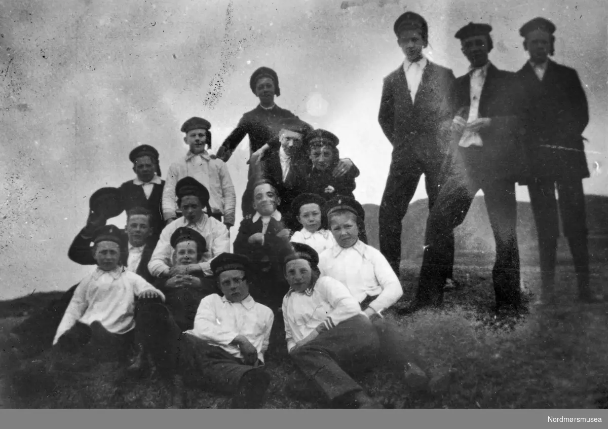 Tekst: "Under oppholdet på Bud". Foto av Kristiansund guttemusikkorps på Bud i Hustadvika kommune. Guttemusikkorpset var på turne til Bud og Molde påsken (5.- 6. april) 1920. Fotografier fra protokollen til Kristiansunds Guttemusikkorps i perioden 1917-1927. Protokollførere var brødrene Hans og Herlof Harstad. Protokollen er i museets privatarkiv under nr. 684. Giver av protokollen er Knut Harstad. Fra Nordmørsmusea sin fotosamling.