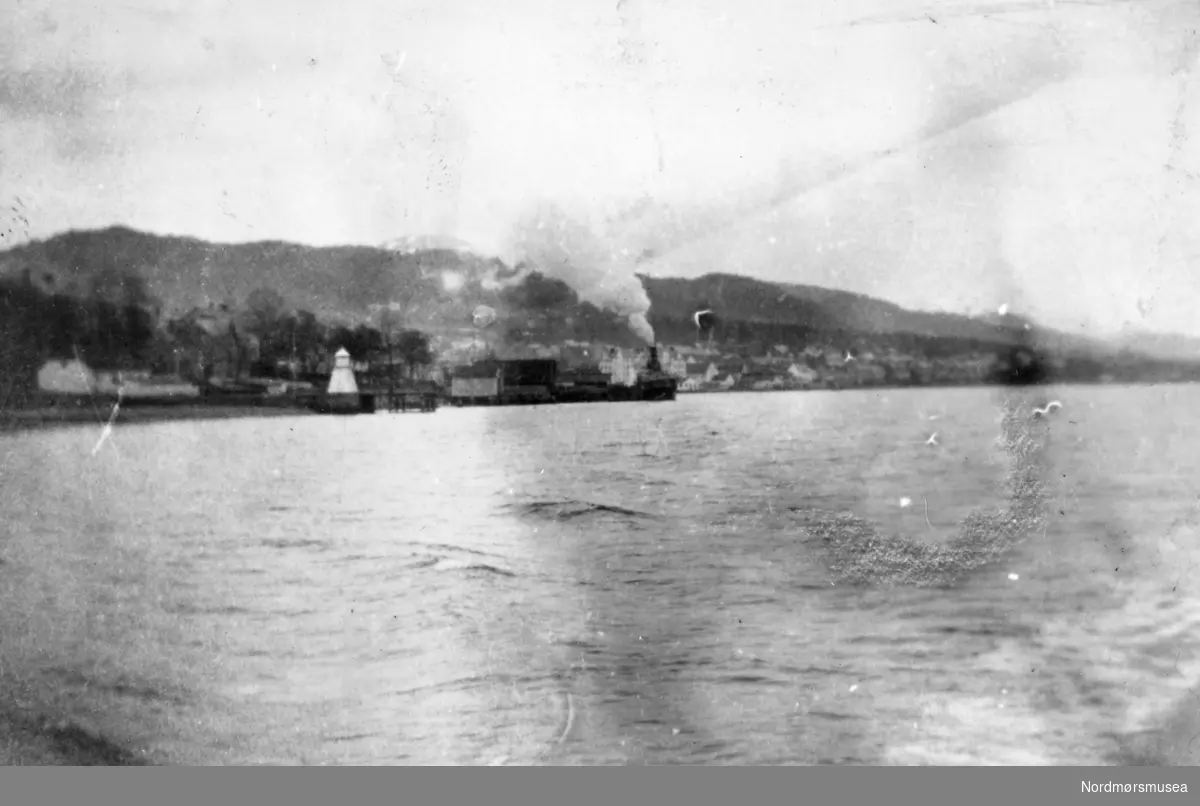 Tekst: "Ved avreisen fra Molde". Kristiansund guttemusikkorps forlater Molde. Guttemusikkorpset var på turne til Bud og Molde påsken (5.- 6. april) 1920. Fotografier fra protokollen til Kristiansunds Guttemusikkorps i perioden 1917-1927. Protokollførere var brødrene Hans og Herlof Harstad. Protokollen er i museets privatarkiv under nr. 684. Giver av protokollen er Knut Harstad. Fra Nordmørsmusea sin fotosamling.