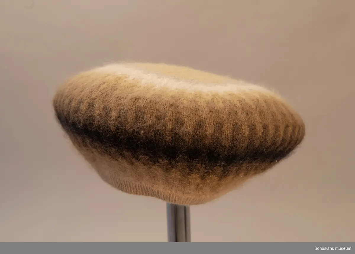 Barett.
Beige, gråbeige, grönbeige, mossgrönt, svart, vitt och grått. Mönster Dadelpalmen, design Kerstin Olson.
Välbevarad