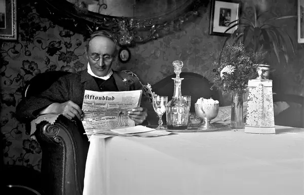 Mathildas far, Wilhelm Ranch, läser iförd glasögon tidningen Göteborgs ...