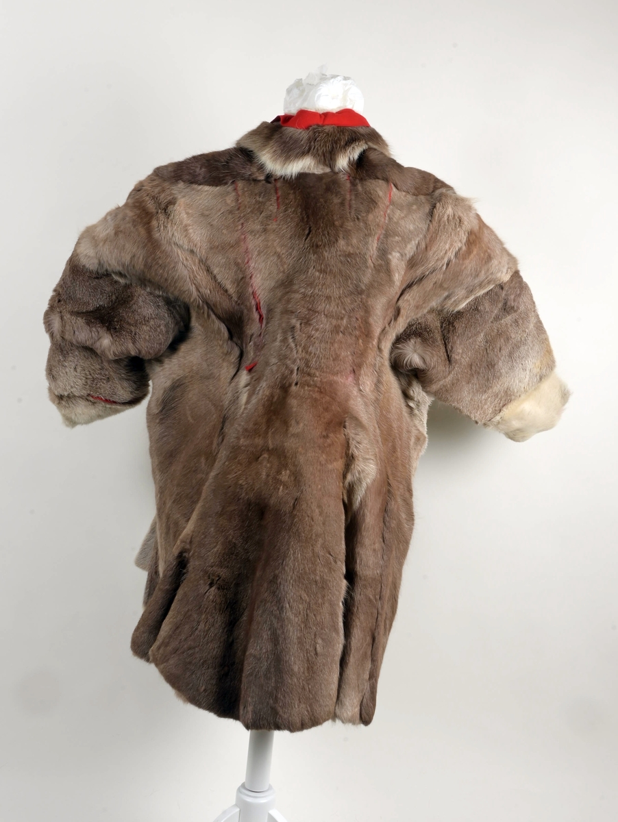 Pesk av reinsdyrskinn med bellinger, kommager og kommagbånd. Pesken har strammebånd rundt halsen. Disse er røde. På ryggen av pesken er det flere paneler. Disse er festet sammen med rødt stoff mellom panelene.
Bellingene er av reinsdyrskinn. Nederst er det påsydd klede, som er i rød tekstil. Øverst har bellingene stramming med tau. I endene av tauene er det dusker i rødt, gult og grønt. Kommagene er av reindyrskinn. Som bellingene har de snøring i toppen med tau. I enden av snøringene er det dusker.  Duskene er i råd og blått. Kommagbåndene er vevd med snøringer i begge endene. I ene ende er det lærbånd til snøring. I den andre enden er det snøringene av ull og med dusk i sine ender.