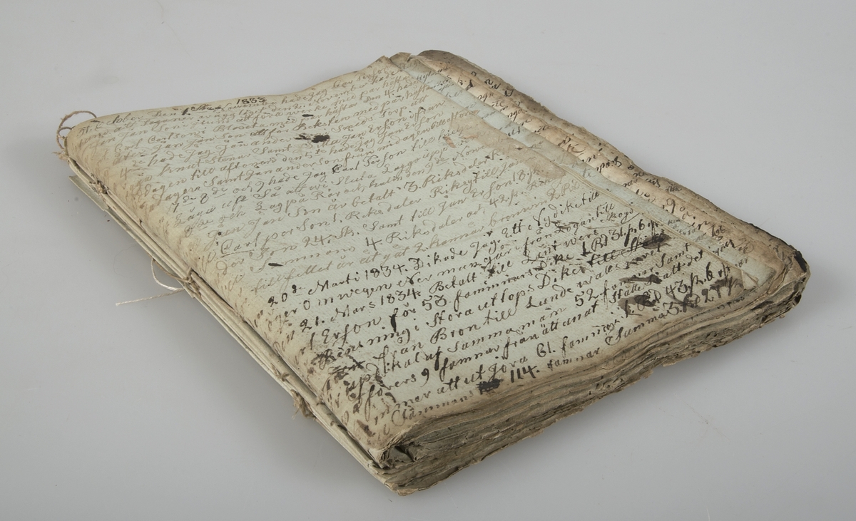 Dagbok i form av lösblad som satts ihop med tråd. Papper i blåaktig respektive gulaktig ton. Handskrivet med bläck.