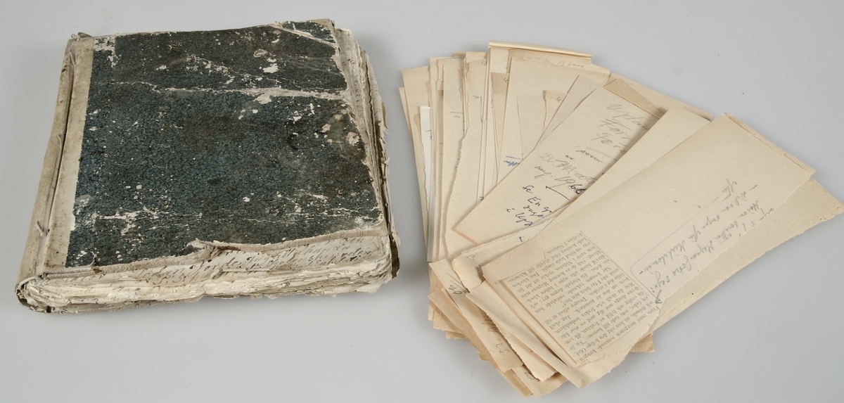 Dagbok i form av lösblad som satts ihop med tråd. Papper i blåaktig respektive gulaktig ton. Handskrivet med bläck. Pärm med blågrönt spräckligt mönster.