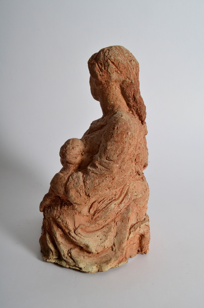 Terrakottafigur som visar ei stjande kvinne med eit born. Motiv frå teikning av Michelangelo eller Rafael.
