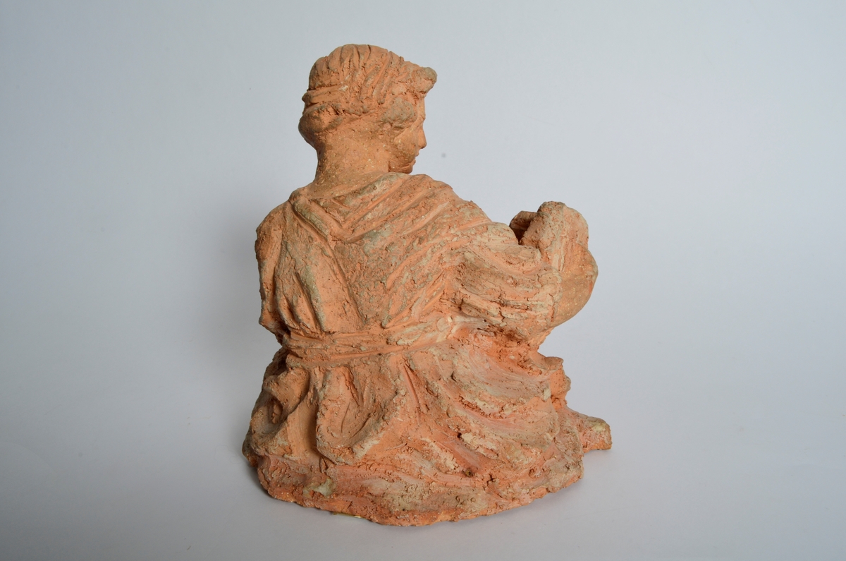 Terrakottafigur som visar ei stjande kvinne som les for eit born. Motiv frå teikning Michelangelo eller Rafael.