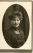 Kabinettsfotografi: en okänd kvinna med tjockt mörkt hår i mörk klänning.