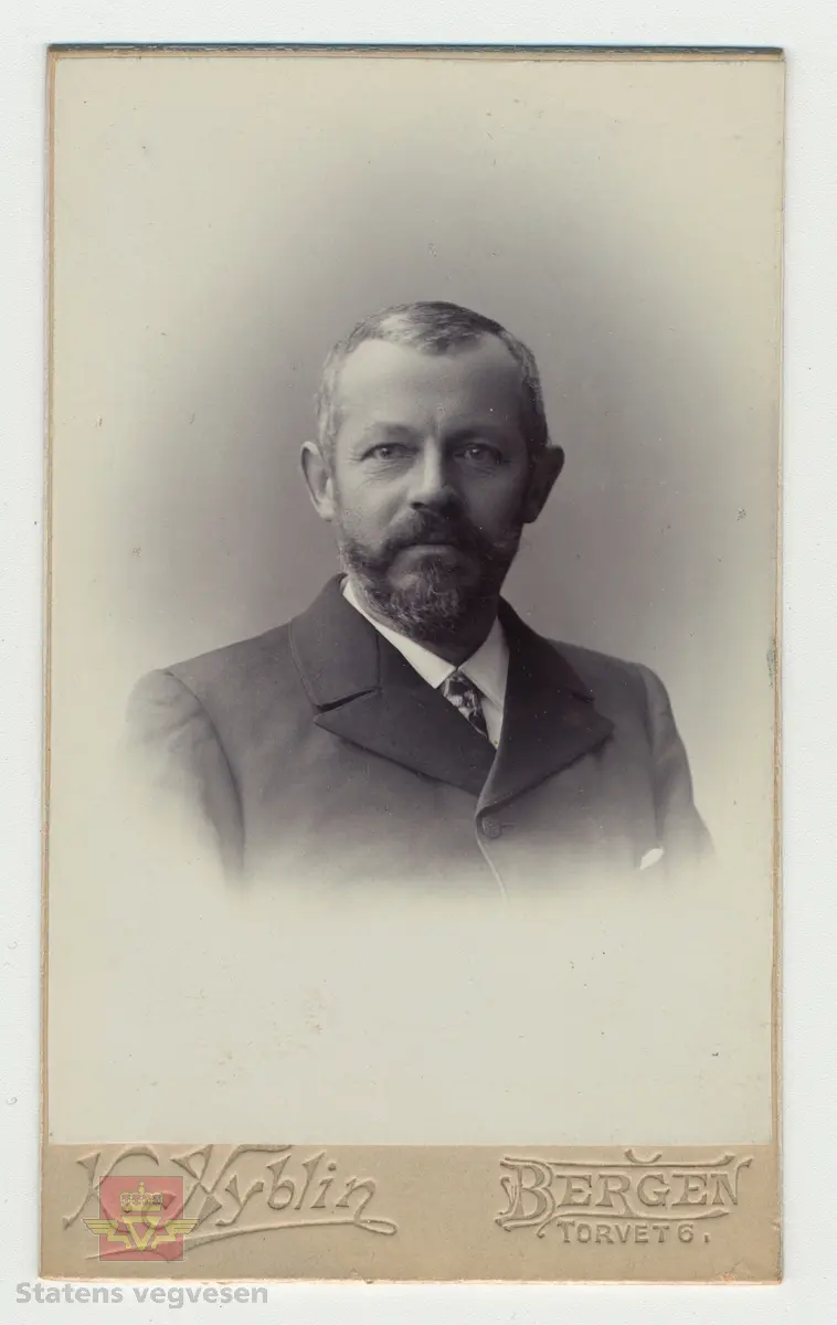 Bilde 1) I følge tidligere registrering og merking på baksiden av bildet: Arbeidslag ca. 1905 - 1915. Midt i bildet amtsingeniør Landmark sammen med Røldøler. Utlånt fra Hordaland vegkontor (Nonås)
Mest sannsynlig er det amtsingeniør Johan Peter Berg Landmark som sitter midt på bildet (med krossreim). Han var amtsingeniør i Hordaland fylke 1894 - 1919. 
Ved siden av ham til høyre på bildet sitter en smed med smedforkle.
Bilde 2 og 3) Visittkort av Johan Peter Berg Landmark, framside og bakside, i album fra "Statens veivæsens Ingeniører." 
Bilde 4 og 5)  Visittkort av Christopher Engebreth Borch, framside og bakside i album fra "Statens veivæsens Ingeniører." 
Bilde 6 og 7)  Visittkort av Hans Hagerup Krag, framside og bakside i album fra "Statens veivæsens Ingeniører." 
Bilde 8) Framside av visittkortalbum fra "Statens veivæsens Ingeniører." Statens vegvesens ingeniører ca 1859 - ca 1960.

Ref. til "Norges vegdirektører og vegsjefer," av Hans Wangensten Paus. Vedlagt informasjon fra boka, se Nedlastinger.

Gruppebildet er også gjengitt i boka "På god veg - Veghistorie i Sogn og Fjordane," av Kristin Ese, side 74, og med denne informasjon i bildeteksten:
"Vegen gjennom Haukåsgjelet vart bygd i åra 1889-1891. Her er vegarbeidarar fotograferte i samband med fint besøk, vegdirektør Hans Hagerup Krag (med krossreim, i midten)
 og amtsingeniør Christopher Engebreth Borch (med klokkekjede, i midten til høgre)." 
Foto: Ingeborg Vigdal