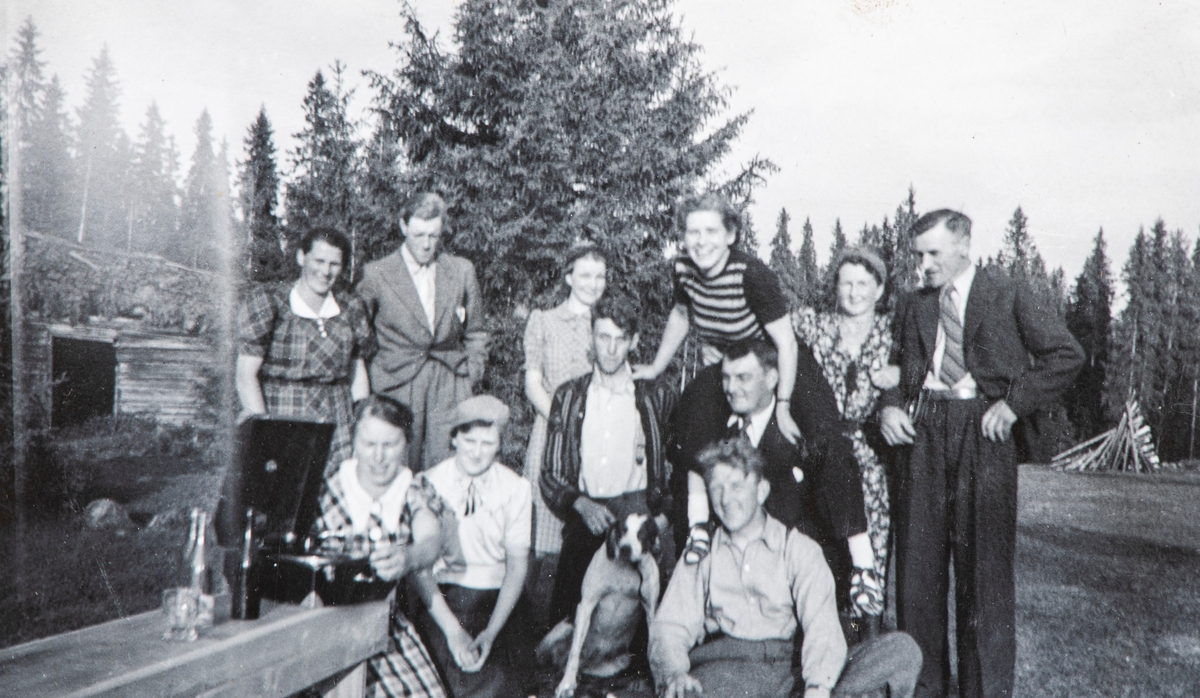 Nysetra 1942. Foran fra venstre med platespiller: Oddrun Storbæk, Tilla Krogsti, hund og Ola Storbæk, i midten Amund Ihrstad, Lars Krogsti med Lisbeth Flagstad på nakken, øvrige på bakerste rad er Marta Tretteberg, Håkon Flagstad, Ingrid Ihrstad, Signe Furuset og Kolbjørn Tretteberg. Disse mennene ble arrestert og satt på Grini fra høsten 1944. Setrene på Nysetra skal ha vært et samlingssted før de ble arrestert .