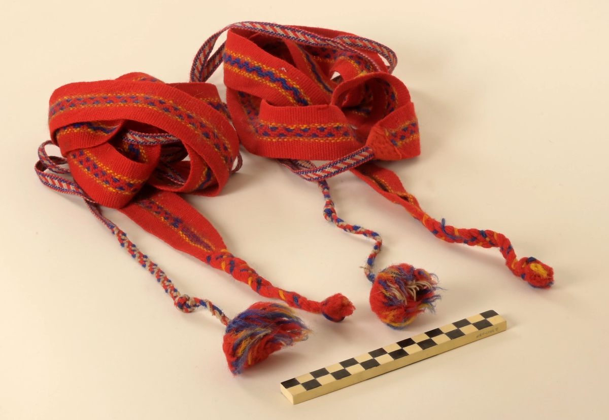 Pesk av reinsdyrskinn med bellinger, kommager og kommagbånd. Pesken har strammebånd rundt halsen. Disse er røde. På ryggen av pesken er det flere paneler. Disse er festet sammen med rødt stoff mellom panelene.
Bellingene er av reinsdyrskinn. Nederst er det påsydd klede, som er i rød tekstil. Øverst har bellingene stramming med tau. I endene av tauene er det dusker i rødt, gult og grønt. Kommagene er av reindyrskinn. Som bellingene har de snøring i toppen med tau. I enden av snøringene er det dusker.  Duskene er i råd og blått. Kommagbåndene er vevd med snøringer i begge endene. I ene ende er det lærbånd til snøring. I den andre enden er det snøringene av ull og med dusk i sine ender.