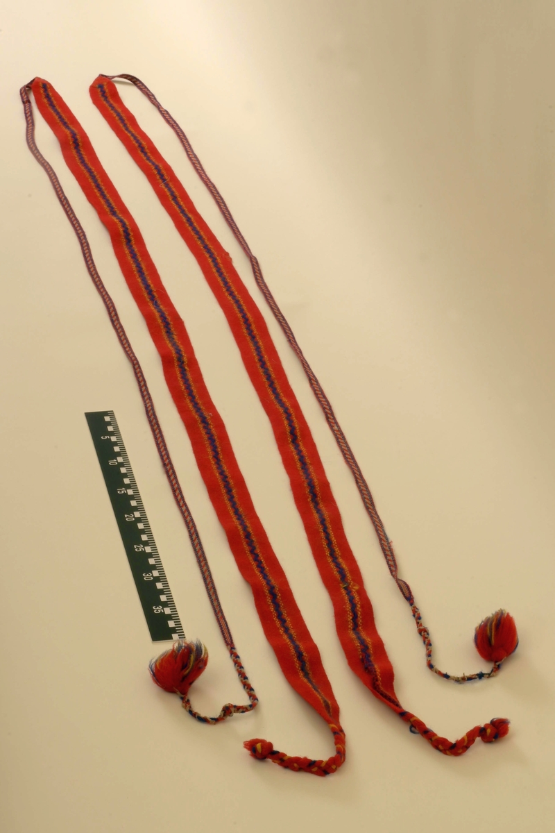 Pesk av reinsdyrskinn med bellinger, kommager og kommagbånd. Pesken har strammebånd rundt halsen. Disse er røde. På ryggen av pesken er det flere paneler. Disse er festet sammen med rødt stoff mellom panelene.
Bellingene er av reinsdyrskinn. Nederst er det påsydd klede, som er i rød tekstil. Øverst har bellingene stramming med tau. I endene av tauene er det dusker i rødt, gult og grønt. Kommagene er av reindyrskinn. Som bellingene har de snøring i toppen med tau. I enden av snøringene er det dusker.  Duskene er i råd og blått. Kommagbåndene er vevd med snøringer i begge endene. I ene ende er det lærbånd til snøring. I den andre enden er det snøringene av ull og med dusk i sine ender.