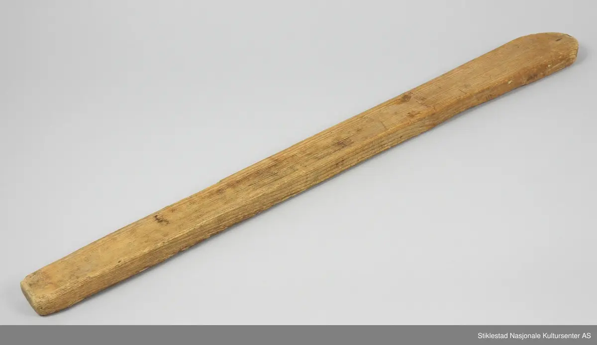 Vasketre/rørespade i gran formet av en smal plank, buet ende. For å røre under kokvask av klær.
