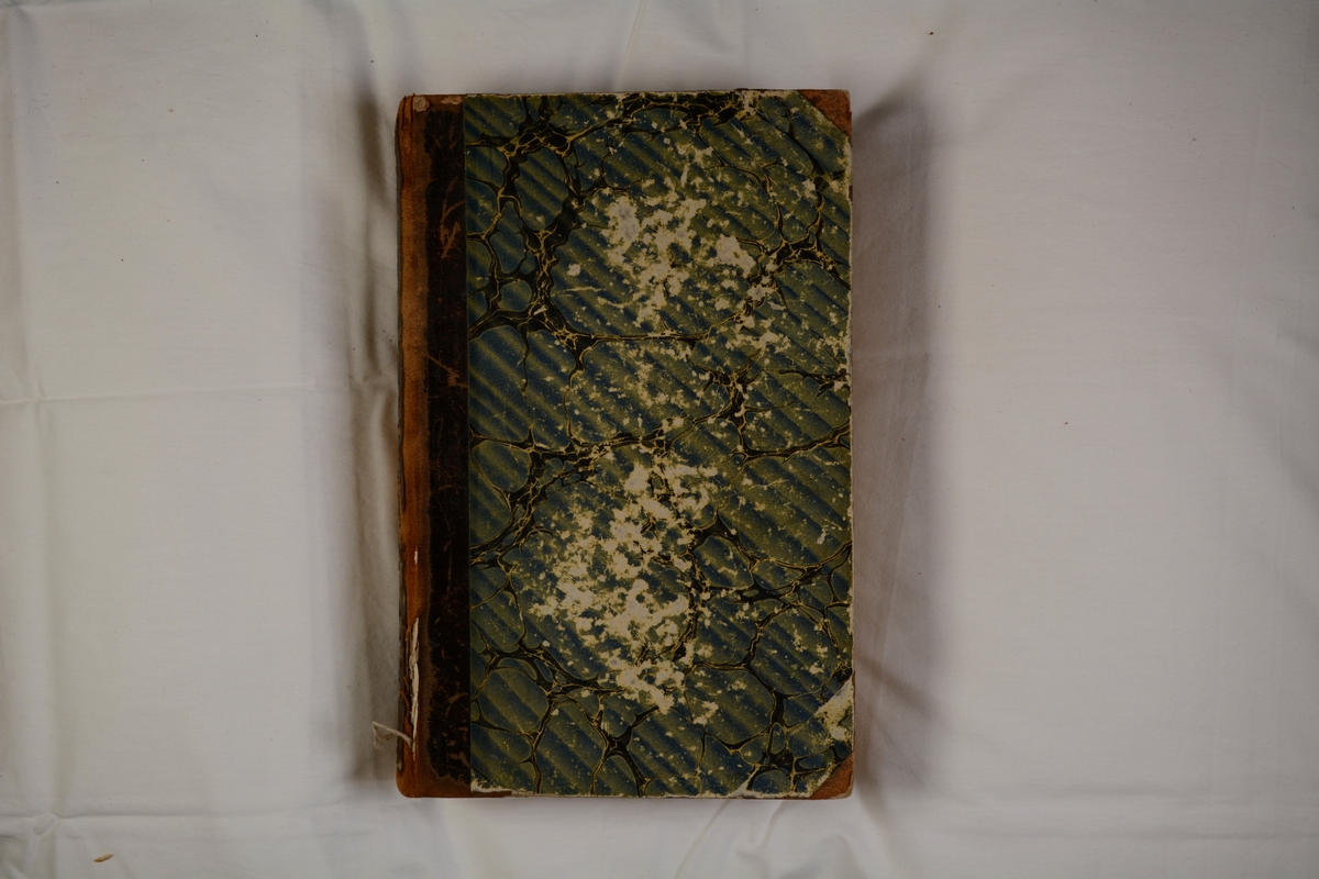 Häftad, halvfranskt, brunt skinnband med marmorerat pärmpapper i blåaktiga nyanser.