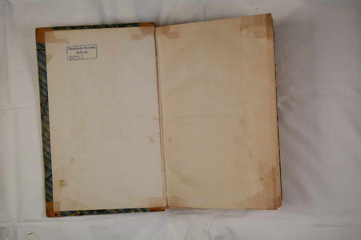 Häftad, halvfranskt, brunt skinnband med marmorerat pärmpapper i blåaktiga nyanser.