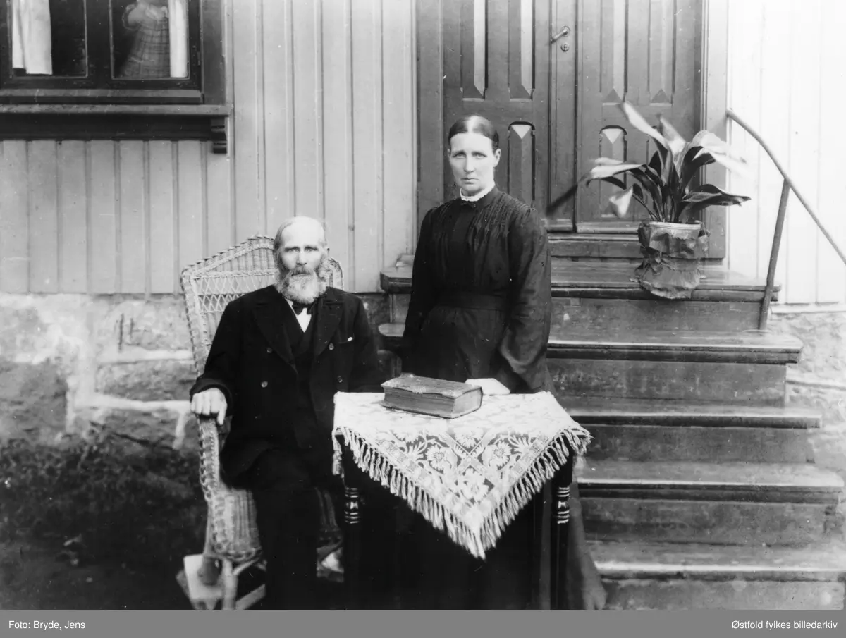 Gustav og kona Grethe Sahlin, fotografert etter 1906. Han var innvandret svenske, sagbruks- og teglverksarbeider. Begge var haugianere, han var form. & søndagsskolelærer på H. N. Hauges Hauges Minde. Mange barn. Bildet tatt foran huset deres som er under rivning 1996. Hun var med i bestyrelsen for kvinneforeninga i 1897.