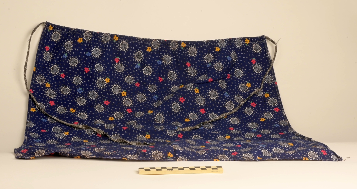 Kofte med lue, belte, forkle og sjal. Lua har dekorbånd nederst langs rimmen. Selve kofta har vevde dekorasjonsbånd på jakkeermene, kragen, oppe på og langs skuldrene, og nederst på kofta. Beltet til kofta låses ved lærreim som tres inn i lås med låsepinne - alt av stål. Selve låsen skjules av beltet da lærreim og lås er på baksiden av beltet. Beltets ende er avsluttet av tynt flettet bånd. Båndet festes i tinnknapp som er på utsiden av beltet. Dette er ei dekorativ løsning for å skjule den funksjonelle stållåsen. Forklet er blått, og dekorert med hvite snøkrystaller og blomster. Blomstene er gule, røde og blå blomser.  Kofta er i svart som er hovedfargen på kofta såvel som lua, mens dekorbånd og lue har andre farger.